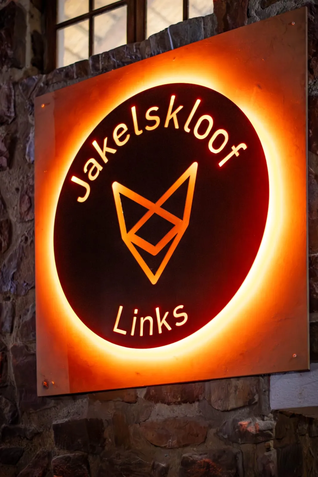 The lit Jakelskloof Links sign on a stone wall